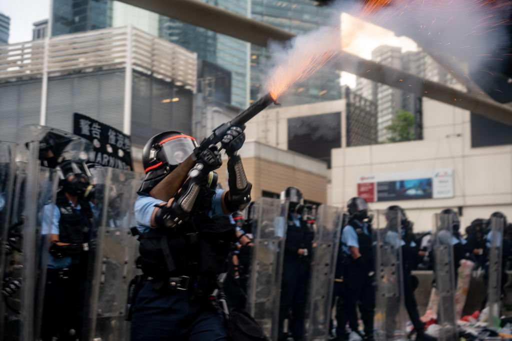 6月12日，一名香港警察正向示威者施放催淚瓦斯。