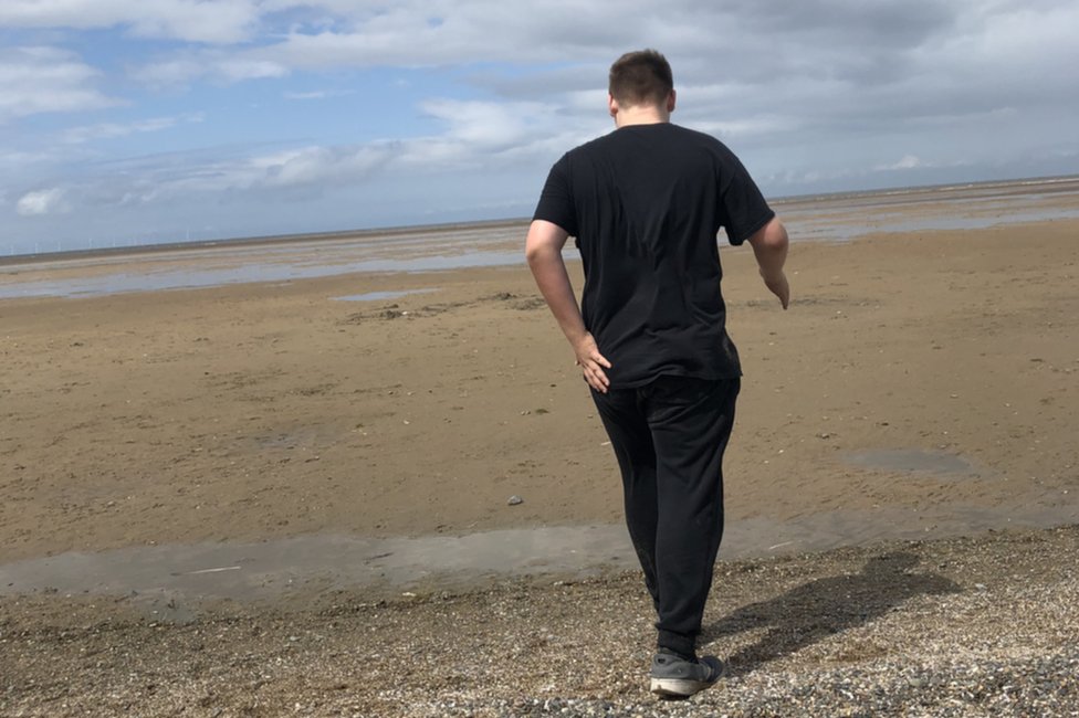Мальчик гуляет по пляжу