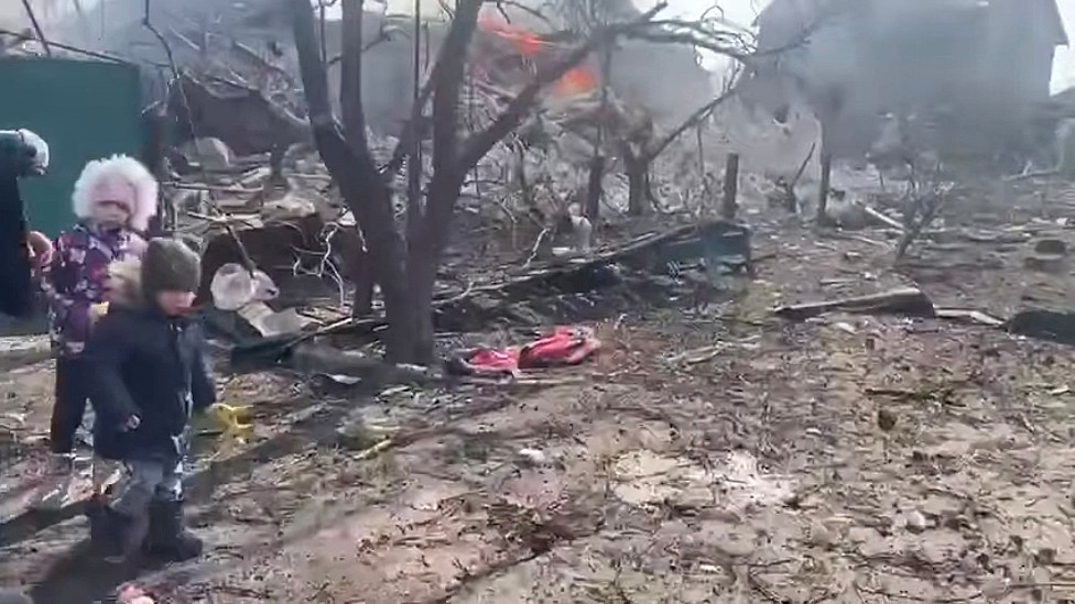 Niños junto a los escombros de una casa destruida por ataques rusos
