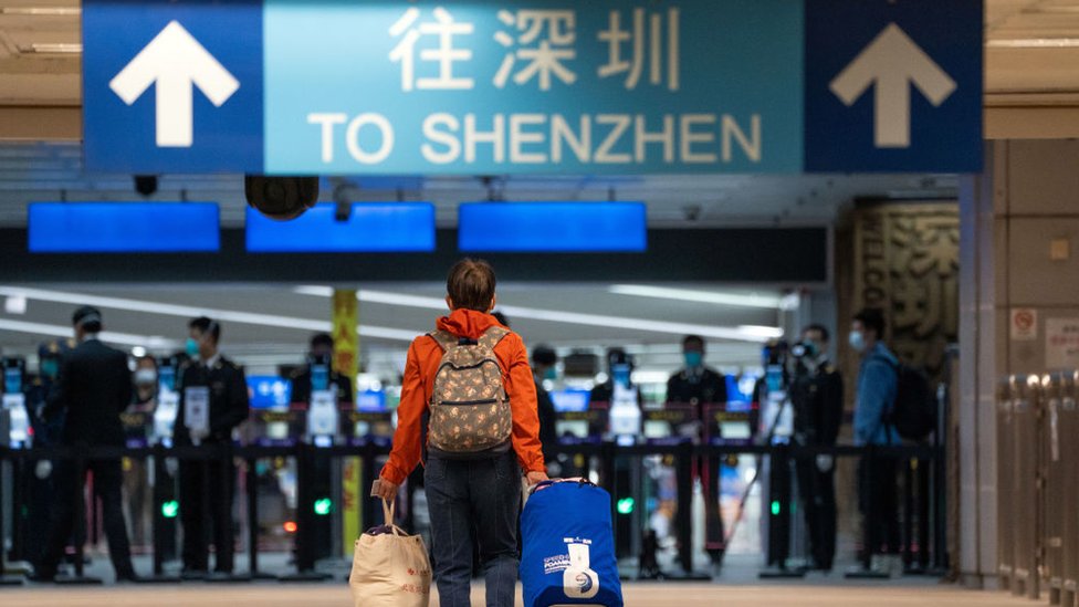 A traveler walks towards Shenzhen in the border control area at MTR Corp. Lo Wu station in Hong Kong,麼愈 China, on Monday, Feb. 6, 2023.