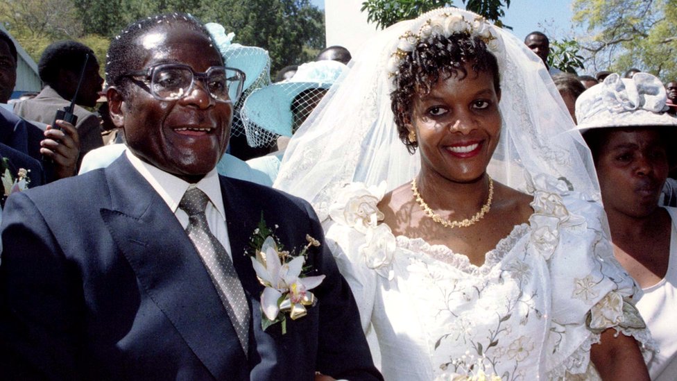 Президент Роберт Мугабе и новая жена Грейс покидают католическую церковь Кутамы в Зимбабве 17 августа 1996 года после обмена свадебными клятвами.
