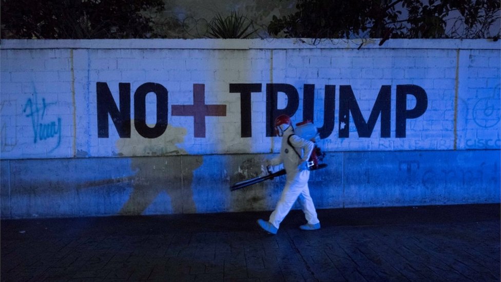 Мужчина проходит мимо граффити, читая «Нет больше Трампа»