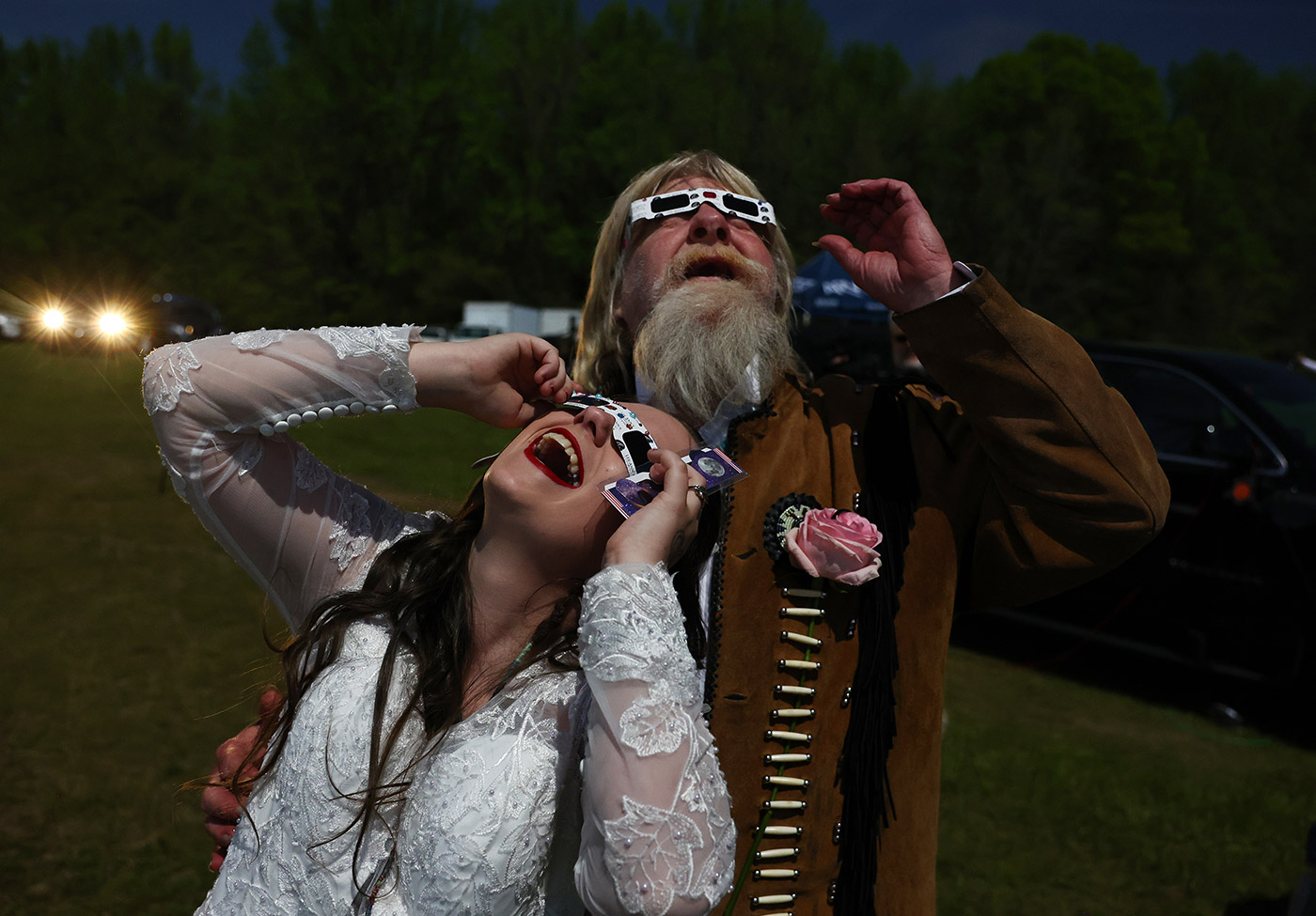 A bride and groom view the solar eclipse after marrying at a mass wedding in Russellville, Arkansas - 8 April 2024 (Mario Tama/Getty Images)