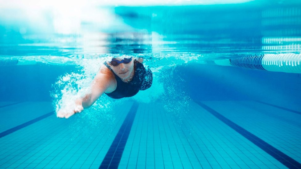 Nadar puede ser una buena manera de dejar que tu mente se despeje y navegue en direcciones inesperadas. Una persona nadando en una piscina