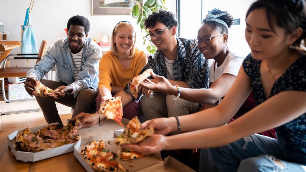 Housemates sharing a pizza