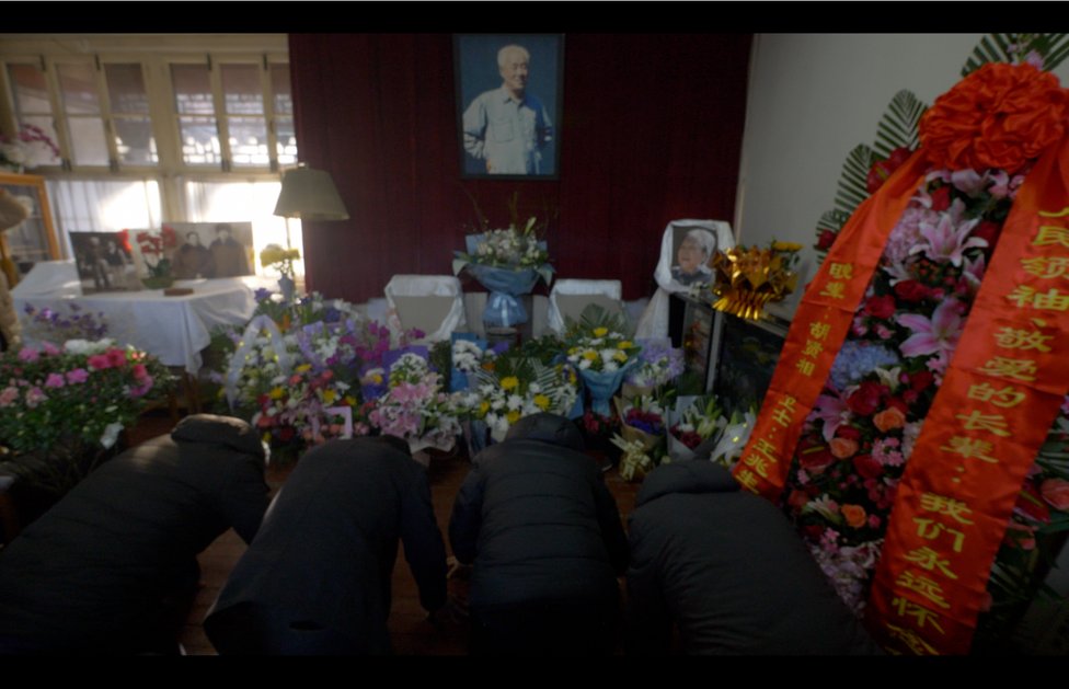 Mourners bow to the photographs of former leader Zhao Ziyang and his late wife Liang Boqi