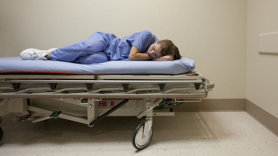 A nurse taking a nap in a stretcher
