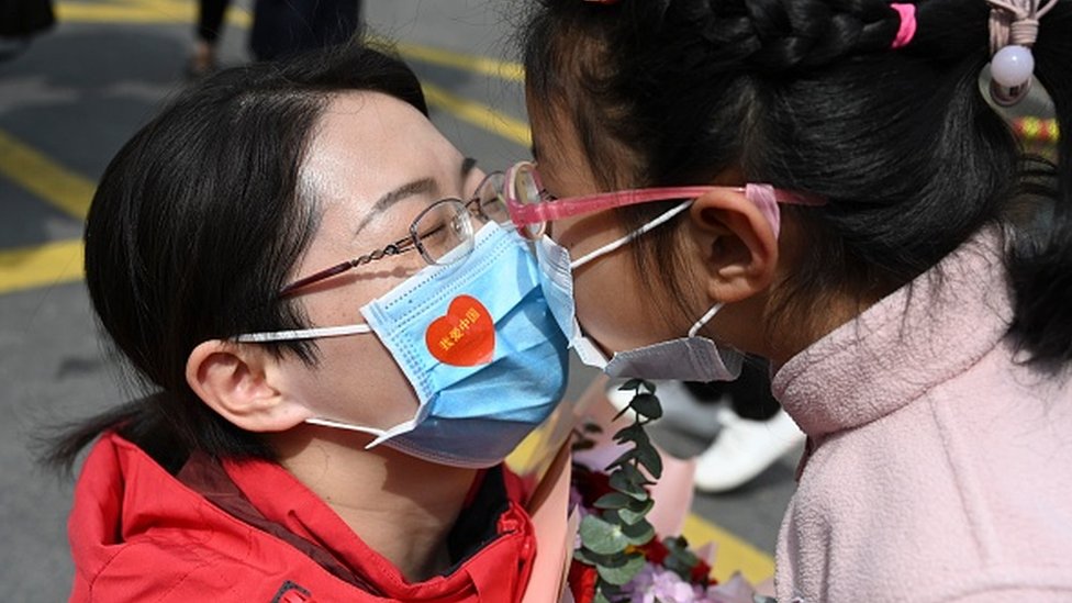 Una mujer y una niña se hacen un gesto cariñoso en China.