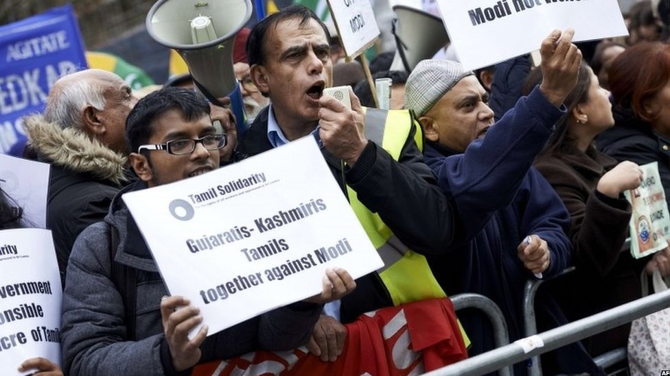 Протестующие, протестующие против премьер-министра Индии Нарендры Моди, держат плакаты у Парламентской площади в центре Лондона 12 ноября 2015 года.