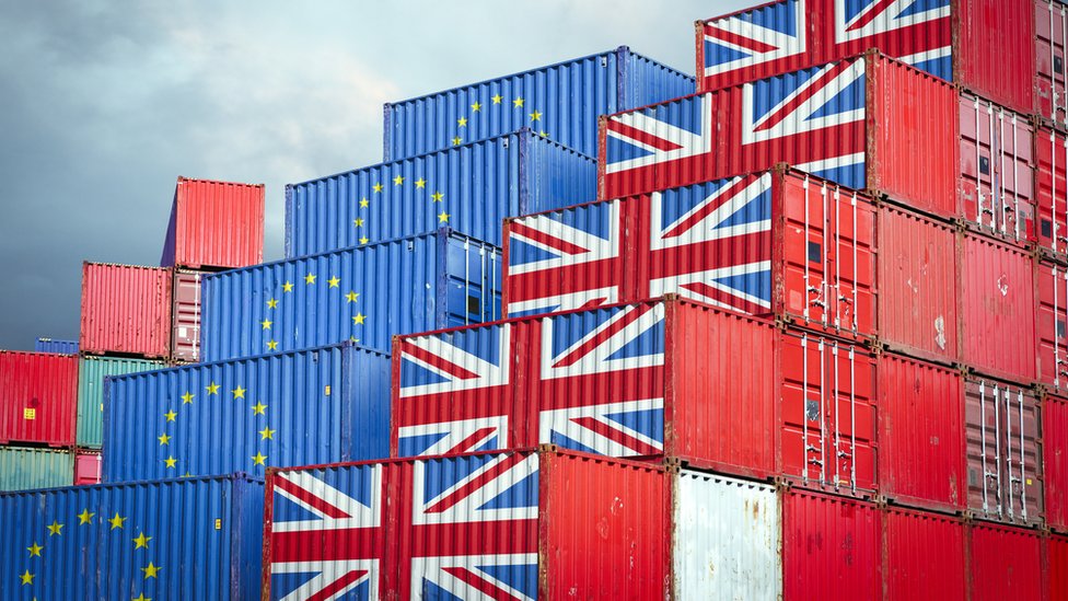 حاويات بضائع تحمل أعلام الاتحاد الأوروبي وبريطانيا تعكس خروج بريطانيا من الاتحاد الأوروبي والقيود المفروضة على التصدير والاستيراد