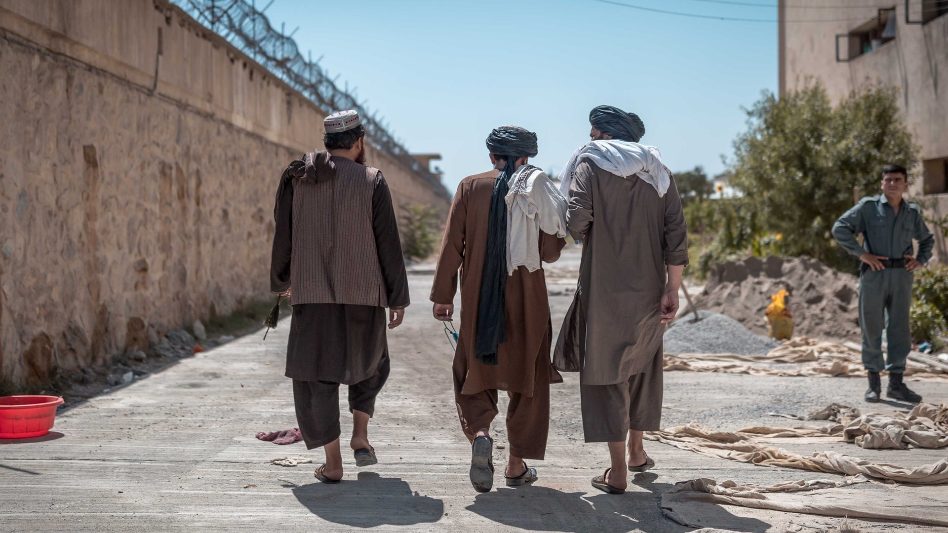 Prisioneros talibanes de espalda en el exterior.