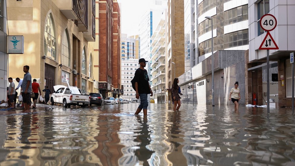 Ljudi hodaju kroz poplavne vode izazvane obilnim kišama u Dubaiju