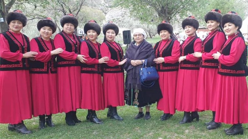 Ainuru Altybaeva standing with a group of women in traditional dress