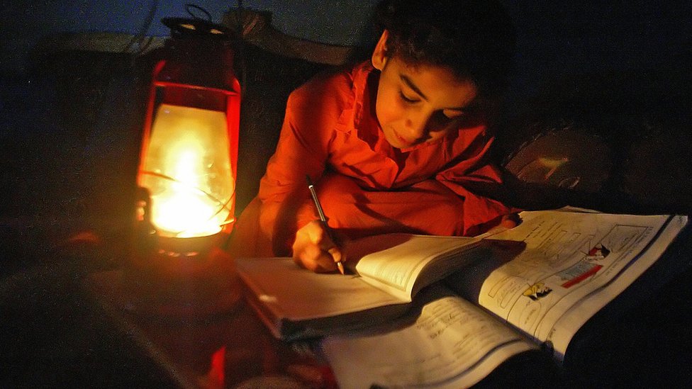 طفلة عراقية تذاكر على ضوء مصباح كيروسين