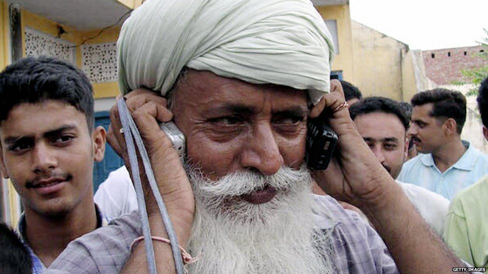Фермер разговаривает по телефону в Индии