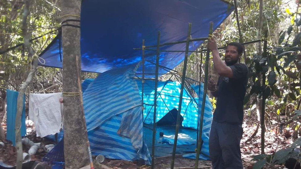 Человек устанавливает палатку из пластиковых отходов.