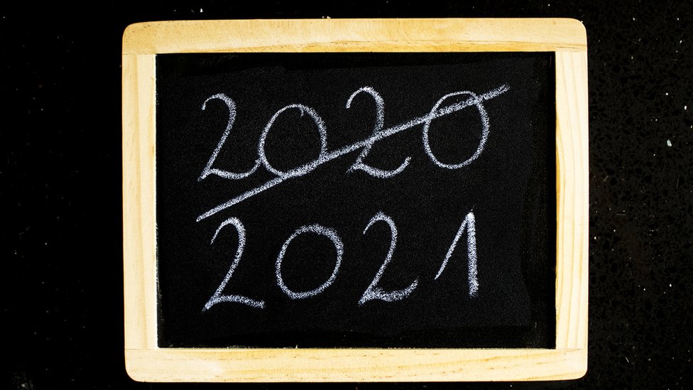 Quadro negro com o número 2020 riscado e o número 2021 escrito abaixo