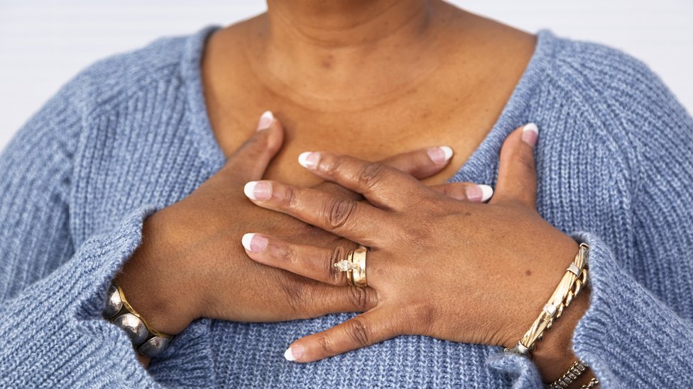 A lady puts her hand on her chest