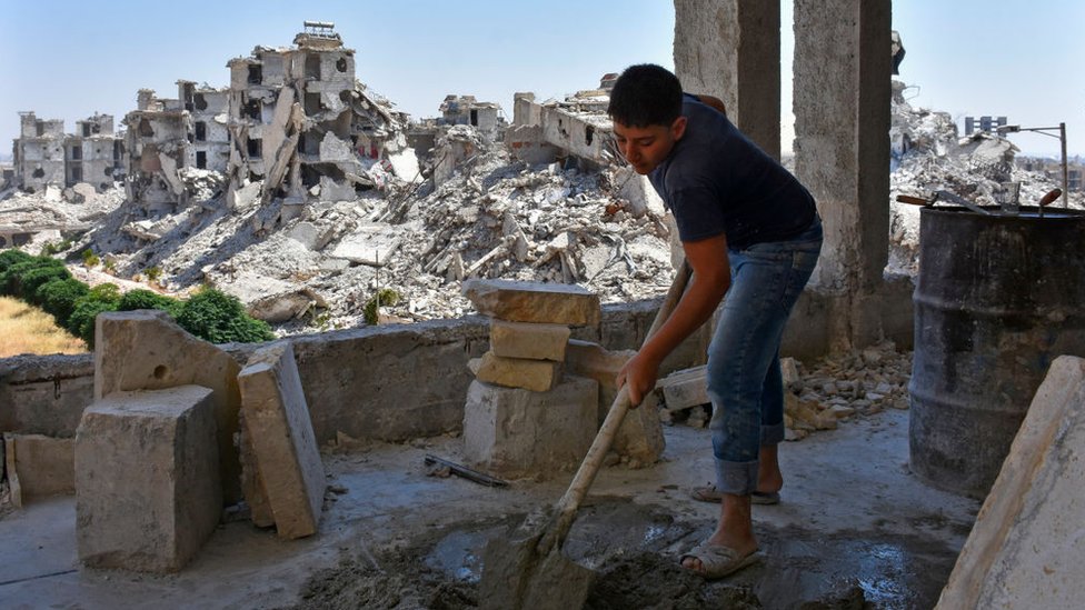 Un joven trabaja en la reconstrucción de casas en Alepo.