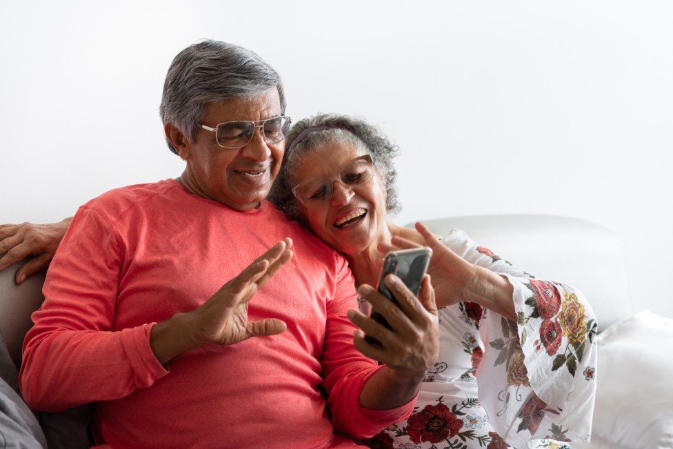 Adultos mayores ven un celular