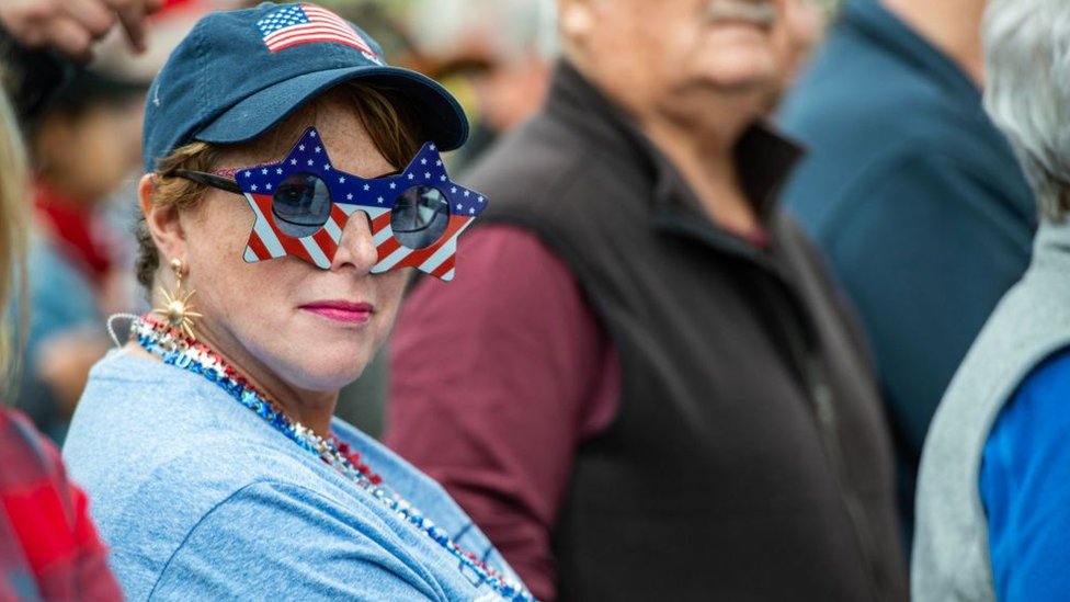 A person wears US flag glasses at a Trump rally in New Hampshire