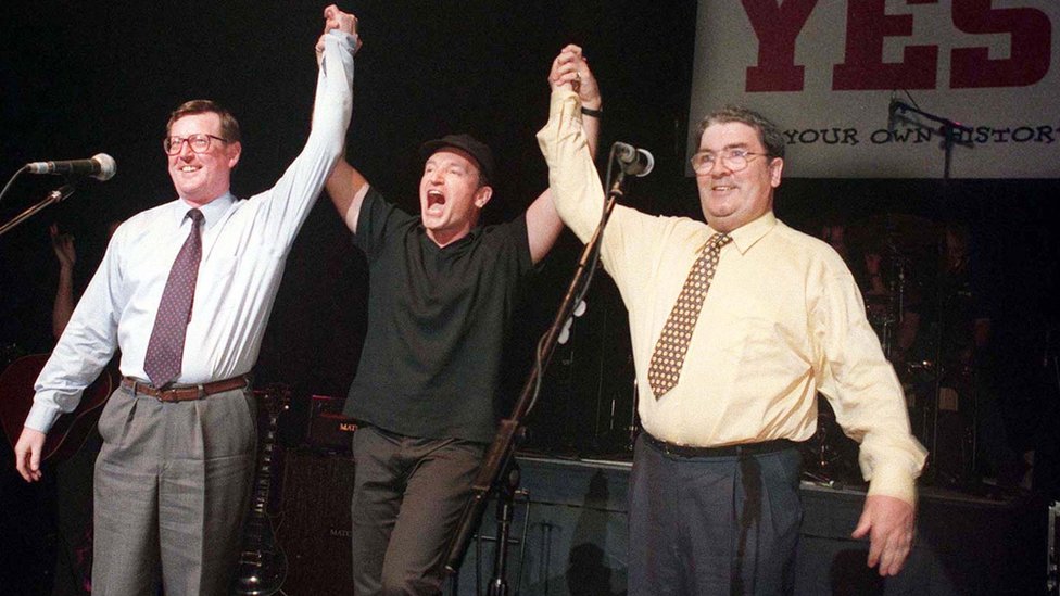 Дэвид Тримбл, Боно и Джон Хьюм вместе на сцене в Белфасте в 1998 году