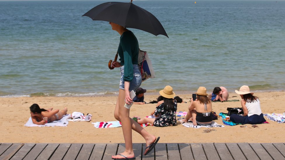Люди стекаются на пляж Сент-Килда, когда волна жары прокатилась по Виктории, Австралия, 18 декабря 2019 г.