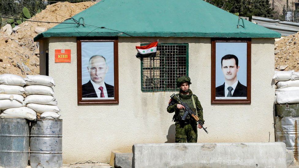 Afiches de Putin and al Asad en un punto de control militar.