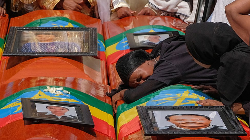 Женщина лежит на гробу во время поминальной службы по эфиопским пассажирам и членам экипажа, погибшим в авиакатастрофе Ethiopian Airways