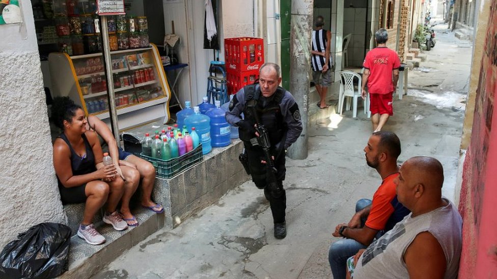 Policial toma posição em meio a operação na favela do Jacarezinho