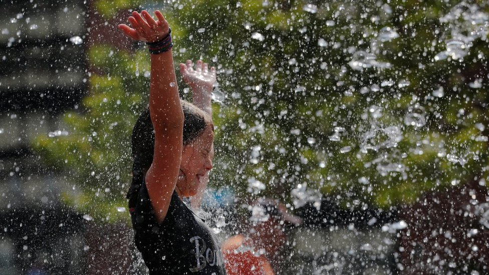 Девушка играет в фонтане на улице Роуз Кеннеди Гринуэй в первый день прогнозируемой летней жары в Бостоне, Массачусетс