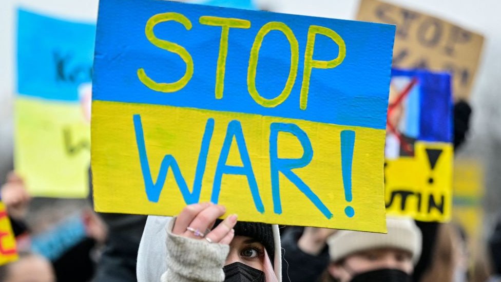شخص يحمل لافتة أوقفوا الحرب