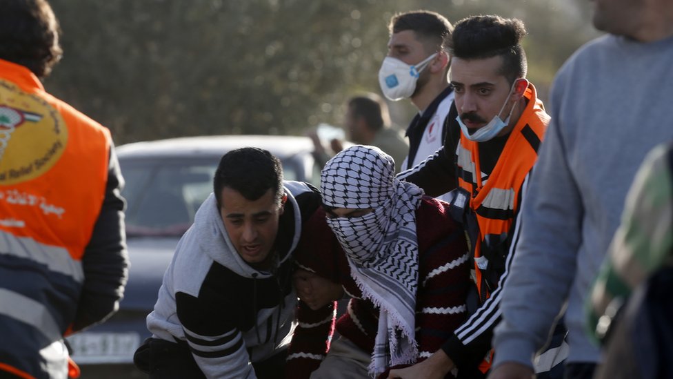 Палестинцы эвакуируют раненого демонстранта во время столкновений с израильскими войсками возле Бейты на оккупированном Западном берегу (11 марта 2020 г.)