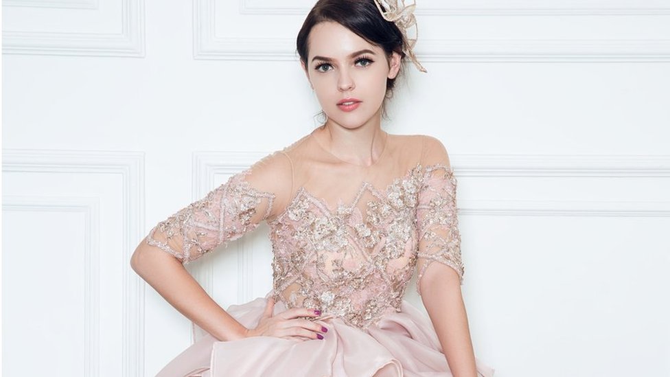 Una modelo con un vestido rosa oro.