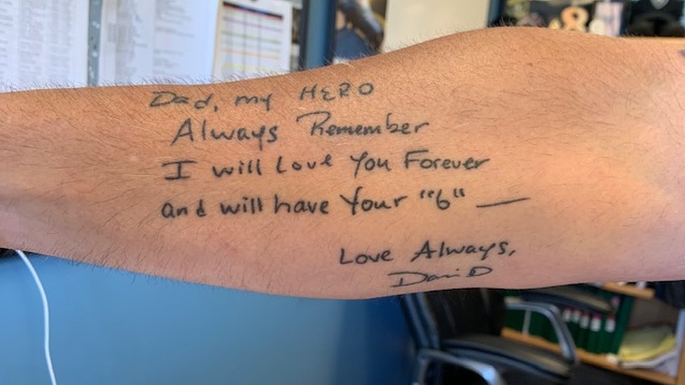 Рука Дэйва Бетца, демонстрирующая татуировку с посланием ко Дню отца, которое сын написал ему на открытке.