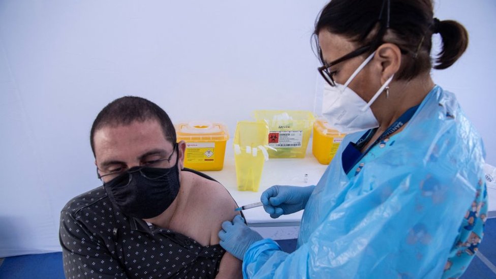 Un hombre es vacunado en Santiago de Chile.