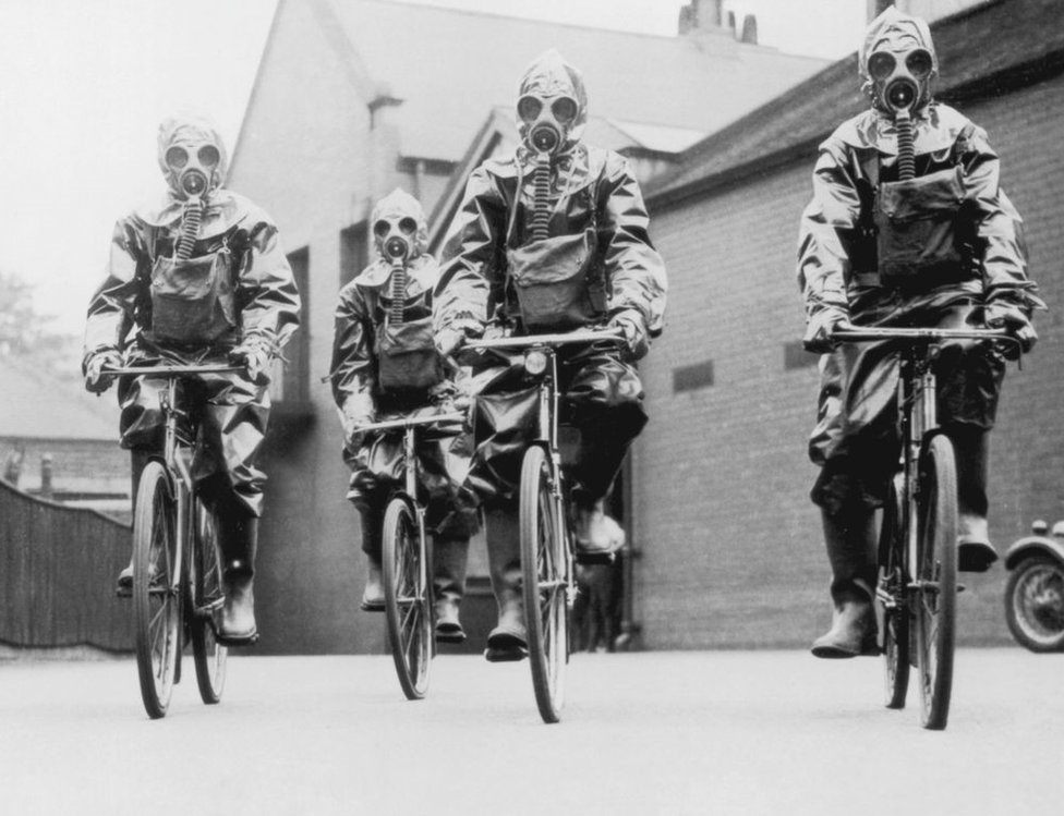 policiais de Londres andando de bicicleta e com máscaras de gás