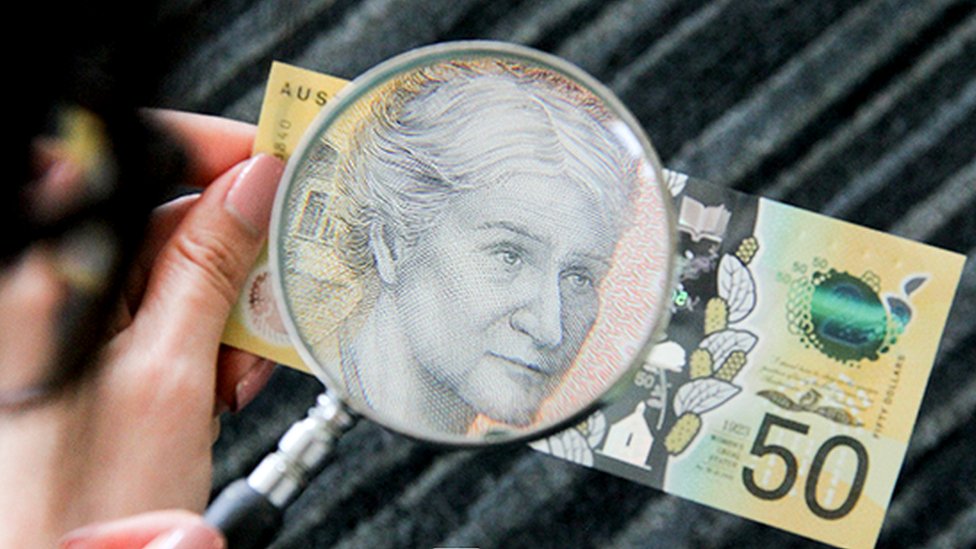 50 dollar note with magnifying glass