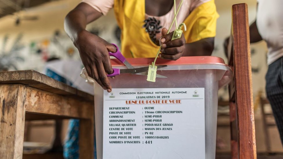 Сотрудник избирательной комиссии срезает печать на урне для голосования на избирательном участке во время выборов в новый парламент в Котону 28 апреля 2019 года.