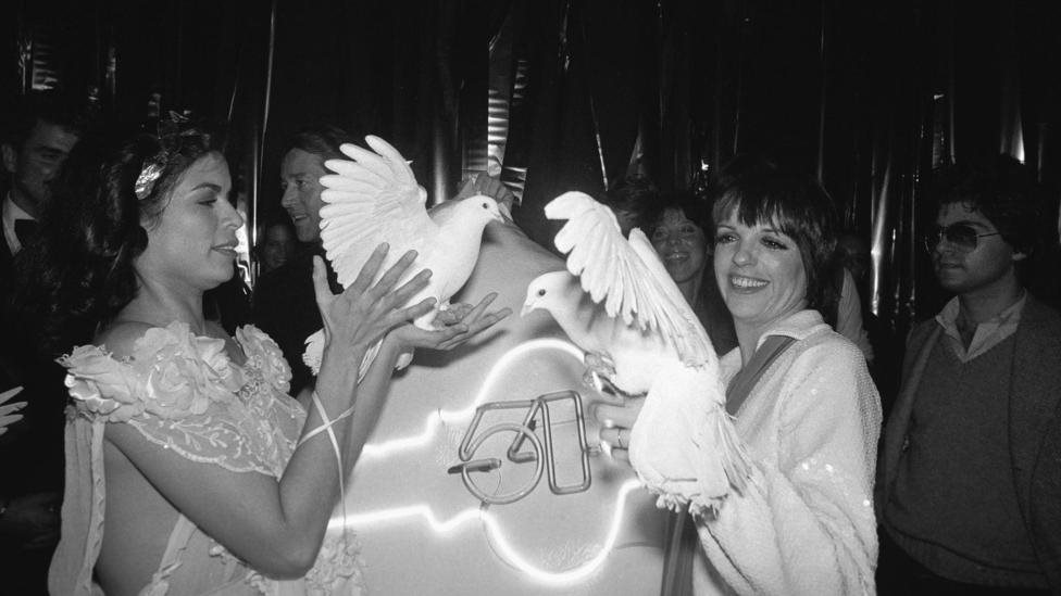 Sebelum pasangan Emanuel terkenal, Bianca Jagger sudah terlihat mengenakan salah satu gaun mereka bersama Liza Minnelli di Studio 54.