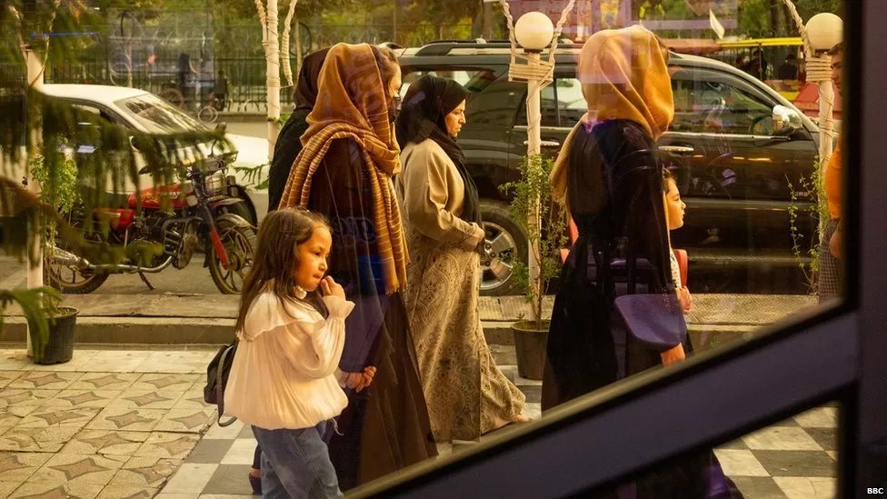 [출처: BBC] 카불의 어느 식당 옆을 지나가는 여성들