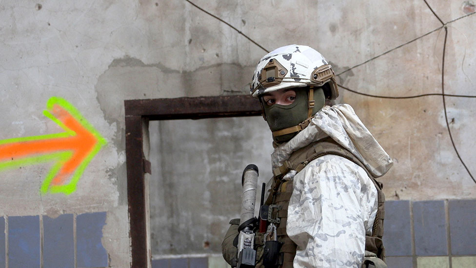 عسكري أوكراني يحرس منطق4ة صناعية مدمرة في بلدة 