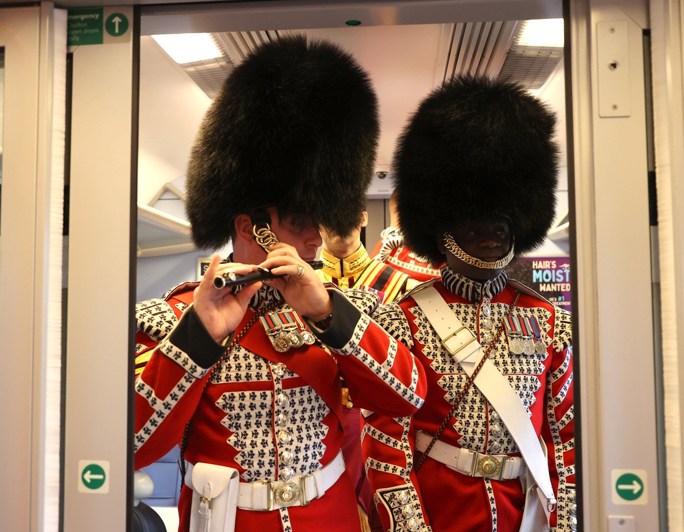 A member of the Armed Forces plays an instrument while on a train into London