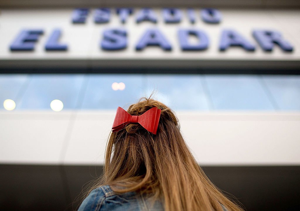Una mujer enfrente de la entrada principal en el estadio El Sadar.