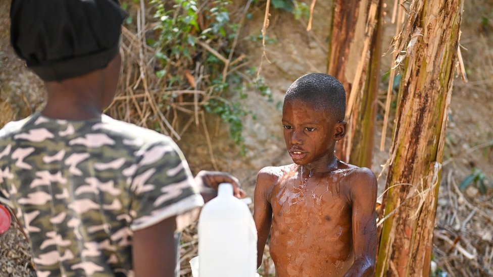 A child washes in the Petion-ville neighborhood of Port-au-Prince, Haiti