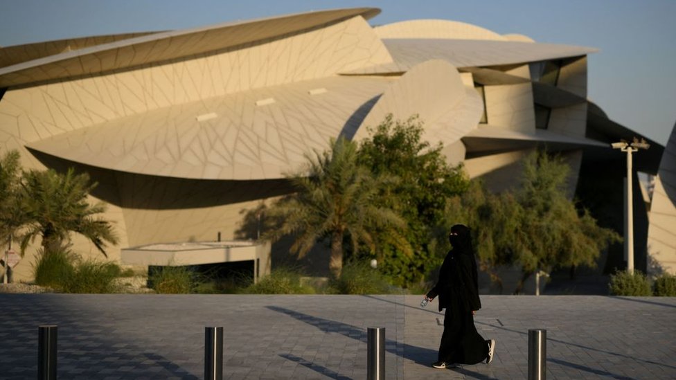 Mujer camina cerca del Museo Nacional qatarí