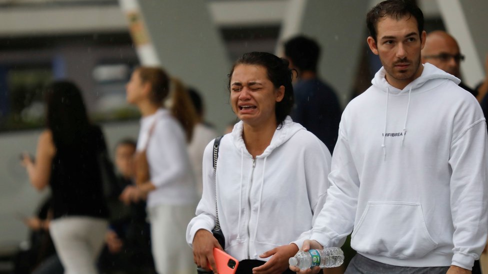 Mujer llora a las puertas del centro de reunificación familiar tras el colapso de un edificio en Surfside
