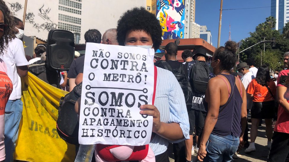 Manifestante segurando cartaz: 'Não somos contra o metrô, somo contra o apagamento histórico'