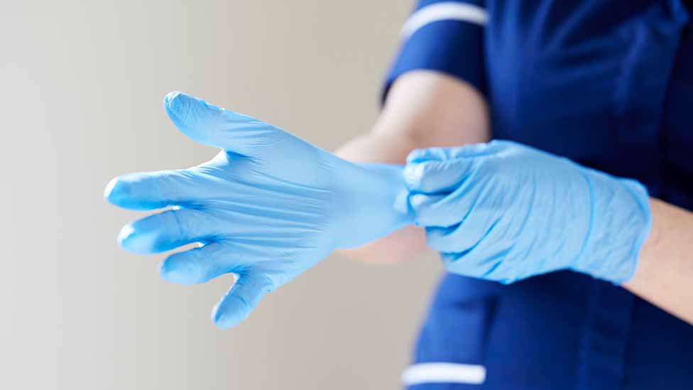 медсестра надевает перчатки