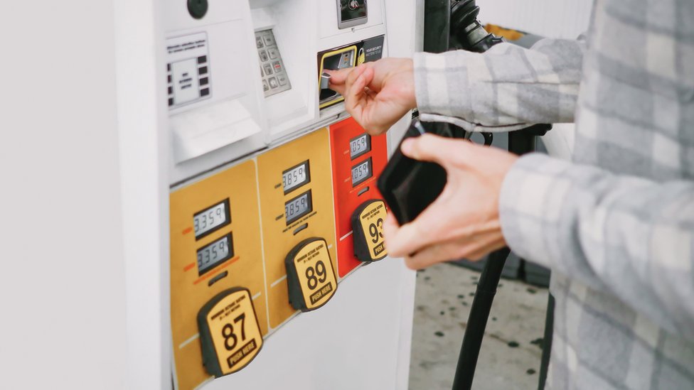 Stock image of a man paying for petrol at a fuel pump